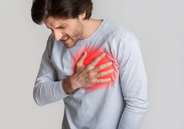 Концерт по болезни сердца. Человек держит грудь, выделенная красным
 - Фото, изображение