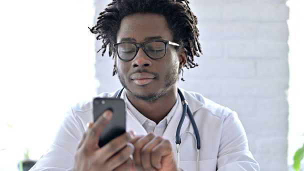 Porträt eines afrikanischen Arztes per Smartphone - Foto, Bild