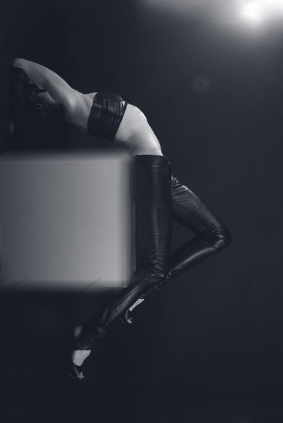 Девушка в кожаном бюстье и брюках на кубе
 - Фото, изображение