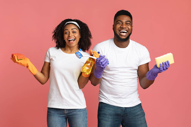 Positive black man and woman holding cleaning tools and laughing - Photo, Image