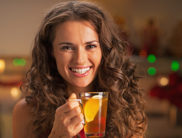 Portrait of smiling young woman with cup of ginger tea - Photo, image