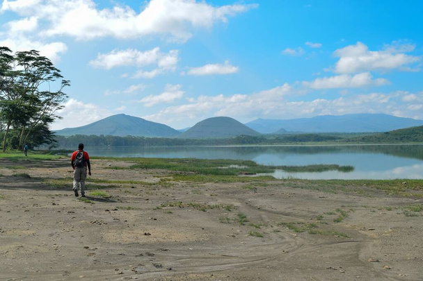 ケニア、ナイバシャのエレマタ湖の岸に沿ってハイカー - 写真・画像