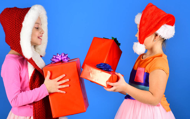 Childhood and leisure concept. Kids in Santa Claus hats - Фото, изображение