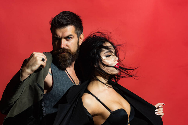 Portrait of sexy couple. Passion and sensual touch. Love concept. Valentines day. Portrait of sensual couple. Brunette girl in a black bra and bearded man on red background isolated. - Foto, Bild