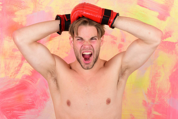 Guy with naked torso wears red leather boxing gloves. - Foto, immagini