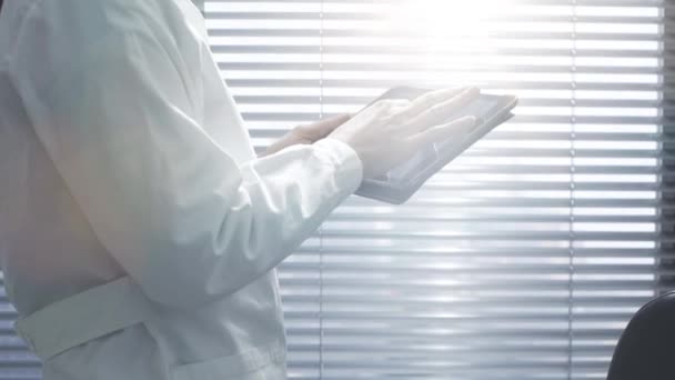 Professional female doctor using a digital tablet - Felvétel, videó
