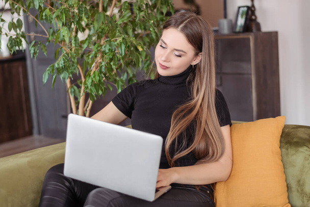 Dziewczyna pracuje w domu na komputerze i laptopie online. Młoda kobieta surfuje po internecie. Kwarantanna i izolacja. - Zdjęcie, obraz