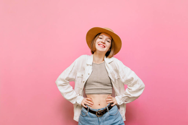 Happy girl in summer light clothing isolated on pink background, stands with her eyes closed and laughs.Portrait of positive pretty girl in summer clothes on pink background, happy with happy face - Фото, изображение
