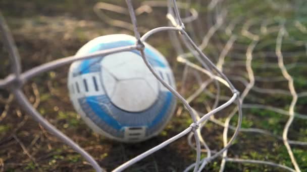 Football goal. The ball flies into the goal. Soccer player scores a goal. Close-up of the grid. Old football field. Street sport. Child Game. The sun shines. - Footage, Video