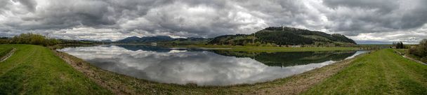 Riflessione di nuvole scure nel lago. Paesaggio panoramico. Serbatoio d'acqua Liptovska Mara e villaggio Vlasky in Slovacchia
 - Foto, immagini