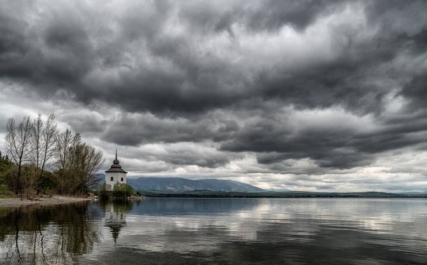 Drammatiche nuvole grigie sul cielo. Riflessioni sul lago Liptovska Mara, Slovacchia
 - Foto, immagini