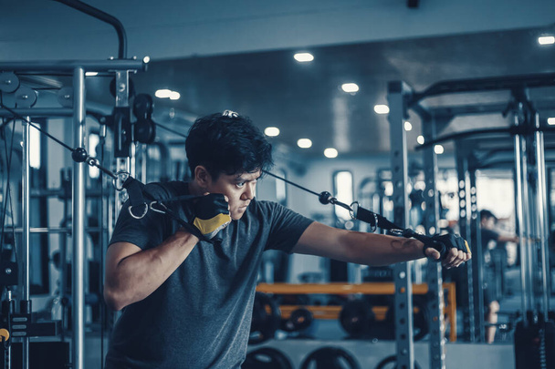 Een man die aan zijn borst werkt met Cable Crossover in Gym. Fitness, workout, sport en gezondheid. - Foto, afbeelding