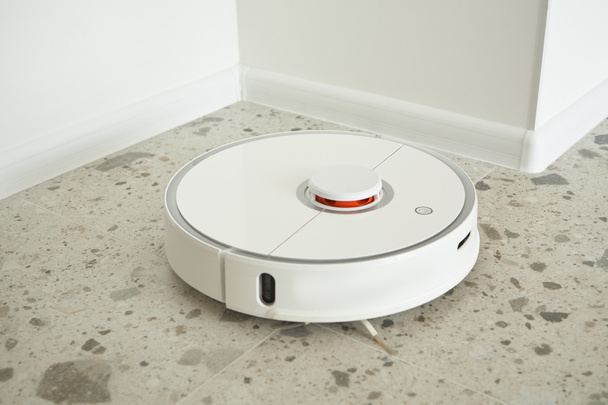 modern automatic vacuum cleaner washing floor tiles in apartment  - Photo, Image