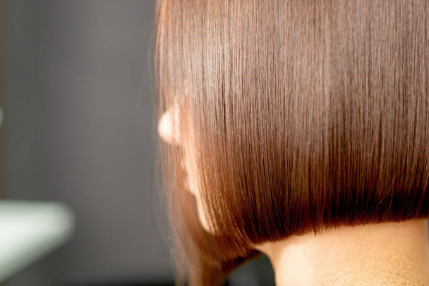 Крупним планом перукарська рука розчісує коротке волосся жінки в перукарні
. - Фото, зображення