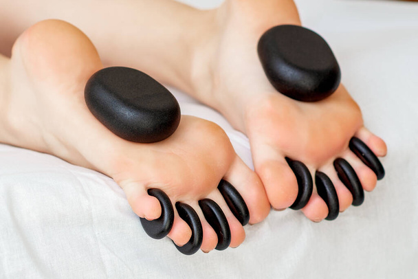 Massage des pieds sur les jambes de la femme par des pierres chaudes gros plan
. - Photo, image