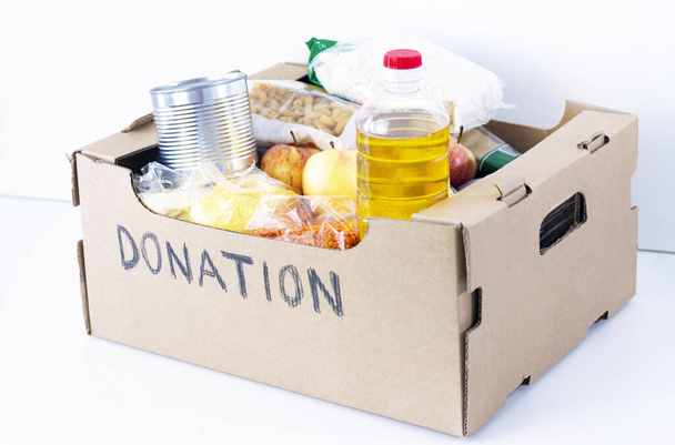 Donation. grocery box, help products for those who need it. donation box. cardboard box with the inscription donation with food on a white background. - Foto, Imagen