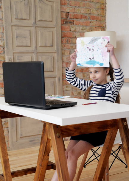 Cute girl with laptop learns painting at home school education.   - Foto, afbeelding