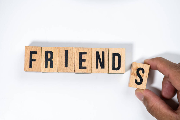 " FRIENDS " text made of wooden cube on  White background with hand. - Fotoğraf, Görsel