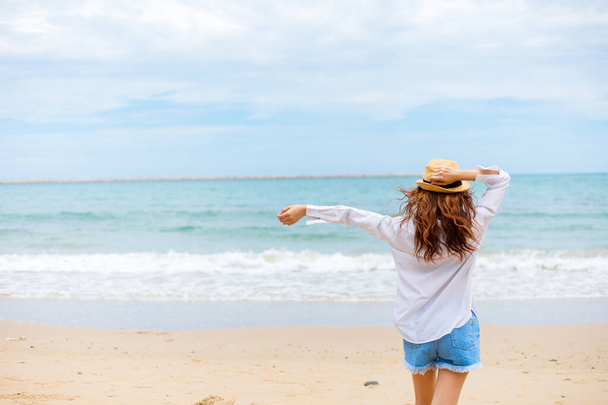 Happy young girl walking on the beach. Summer travel, vocation, holiday concept. - Photo, image