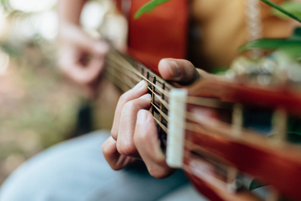 woman's hands playing acoustic guitar have fun outdoor, close up. - Fotó, kép