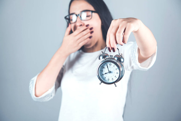 tired woman hand  clock on gray background - Fotografie, Obrázek