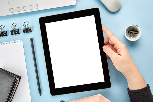 Mockup image of hands holding a digital tablet computer with blank white screen on blue surface. Flat lay - Foto, Imagen