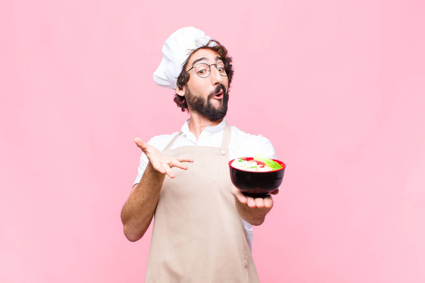 young crazy cool man cooking japanese noodles against pink wall - Φωτογραφία, εικόνα