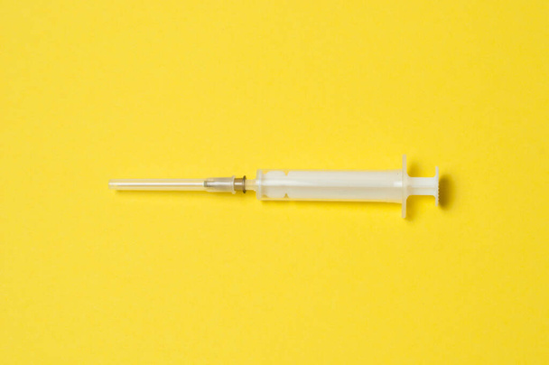 Медицинский шприц выделен на желтом фоне
 - Фото, изображение
