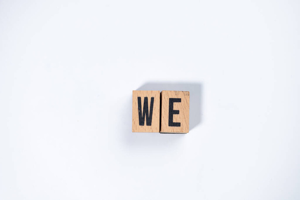 " WE " text made of wooden cube on  White background. - Photo, Image