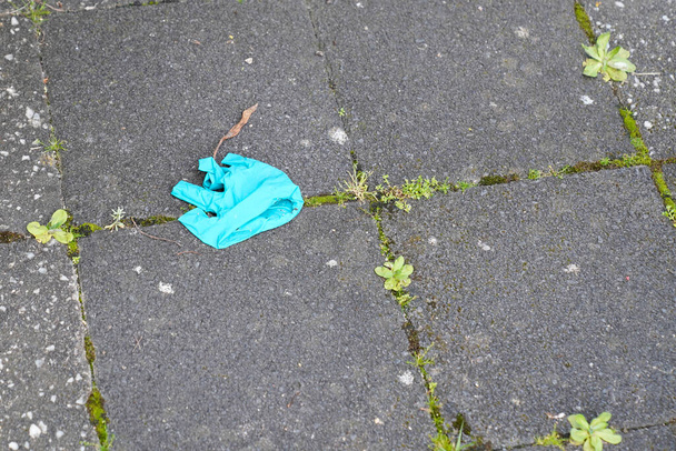 groene coronavirus bescherming gebruikt latex handschoenen verlaten in de straat - Foto, afbeelding