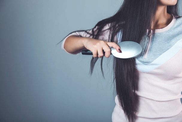 woman comb your hair on dark background - Foto, imagen