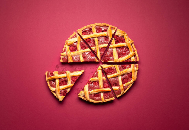 Raspberry pie sliced in equal pieces with lattice crust, on a red background. Top view of raspberry tart with pastry crust. Classic American dessert. - Photo, Image