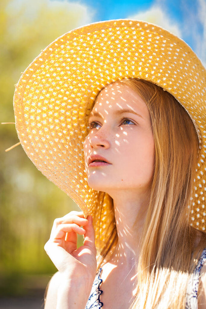 Close up portrait of a young beautiful girl in a straw hat - Фото, зображення