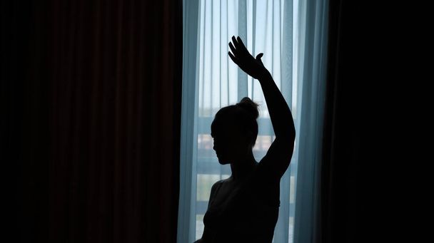 Silhueta de uma mulher na frente da janela
 - Foto, Imagem