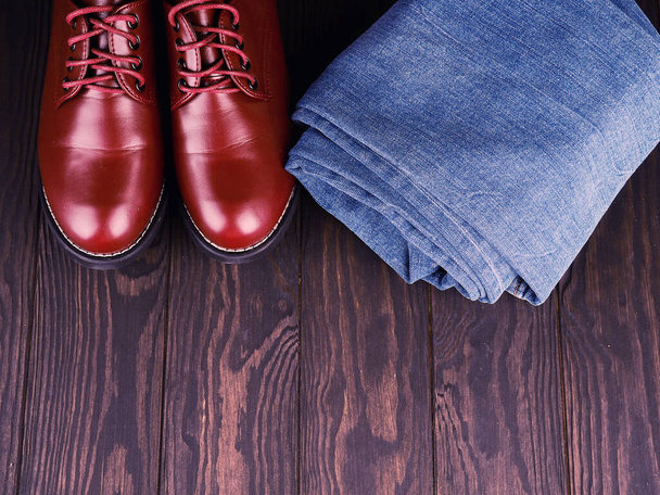 Concept à la mode. casual wear, bottes de travail jaunes en cuir naturel, jean bleu sur fond noir. Tendance casual chaussures vêtements
. - Photo, image