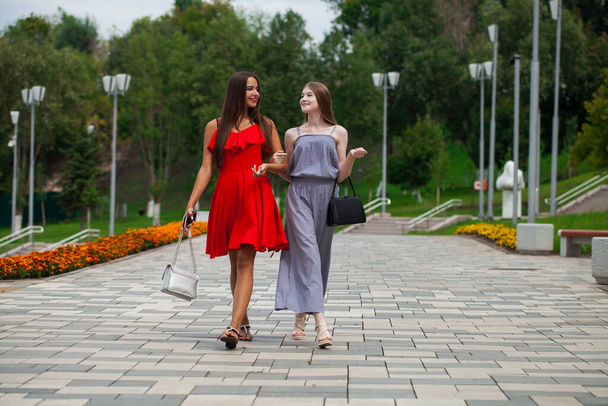 Portrait of a beautiful young two fashion women walk on summer city - Foto, immagini