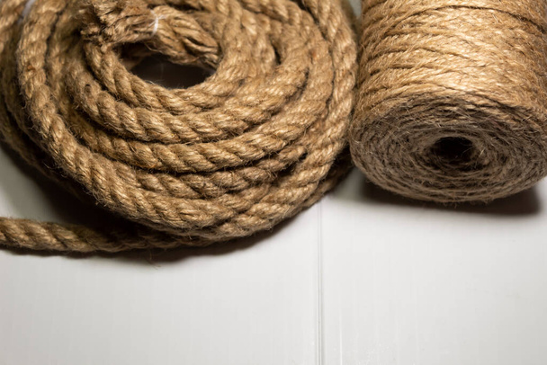 Two skeins of hemp rope thin and thick lie nearby. - 写真・画像