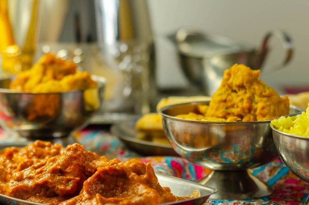 Chicken Madras en Chicken Tikka Masala met Pilau Rice, Naan Breads en, Ui Bhajis, een traditioneel Indiaas gerecht - Foto, afbeelding