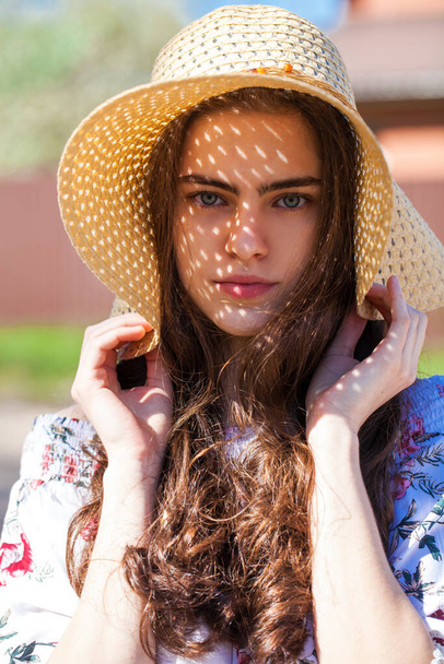 Close up portrait of a young beautiful girl in a straw hat - 写真・画像