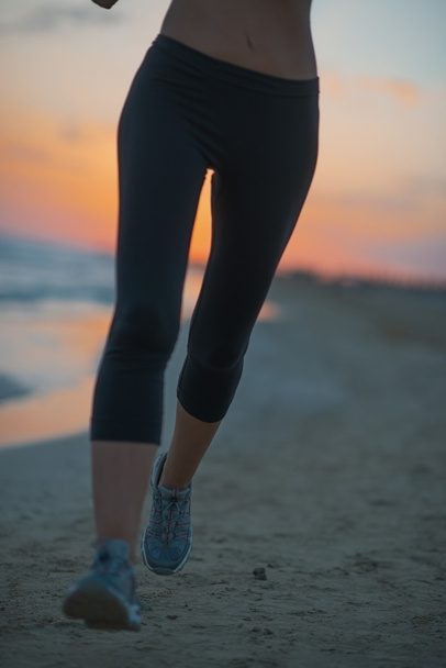 Closeup on fitness woman running on beach at dusk - Φωτογραφία, εικόνα