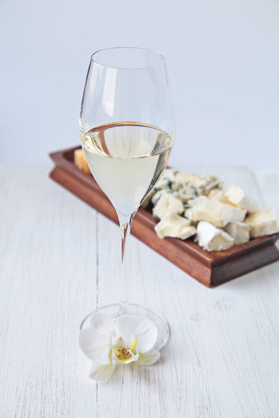 Glass of wine and orchids on wooden background - Photo, Image