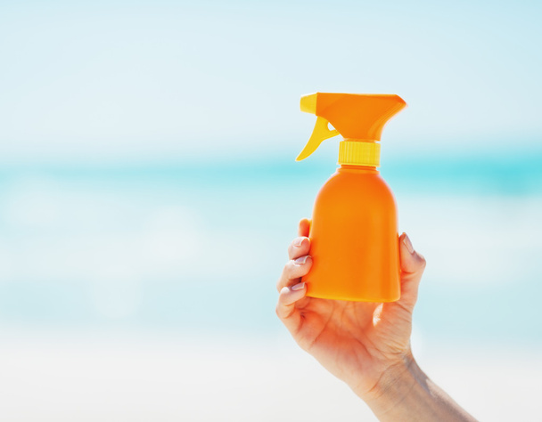 Closeup on bottle of sun screen creme in hand of woman - Photo, Image