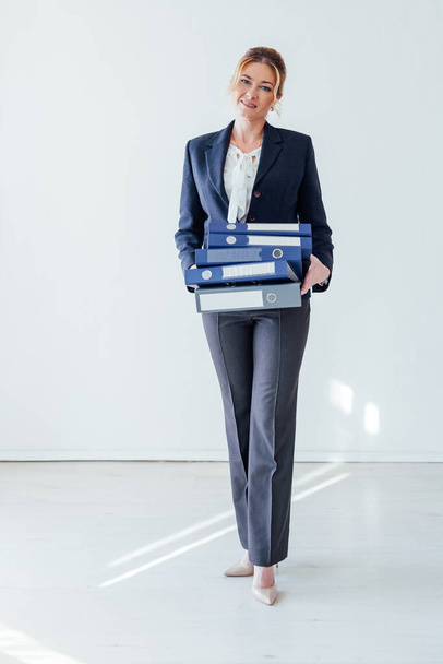 Porträt einer schönen Geschäftsfrau im Business-Anzug mit Ordnern für Papiere - Foto, Bild
