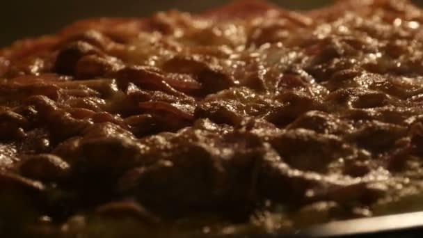 Italiaanse pizza met plakjes salami, waarop thuis kaas wordt gesmolten, gebakken in een oven. - Video