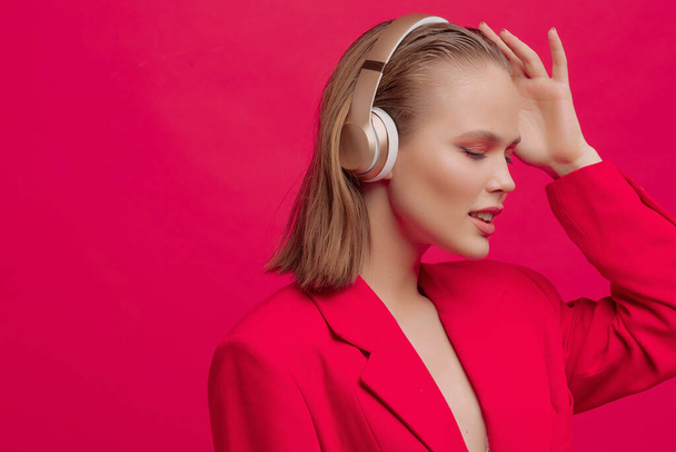 A beautiful young girl in wireless headphones listens to song with a good mood. bright colorful music poster. - Foto, afbeelding