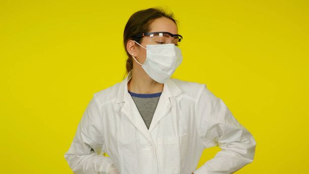 Junger Arzt in medizinischer Schutzmaske, Brille und weißem Mantel - Foto, Bild