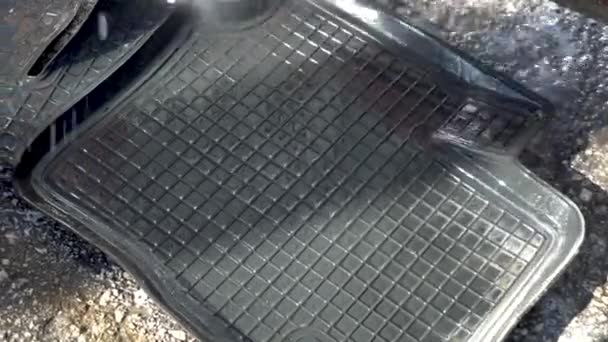 Washes away dirt from a car mat with a high-pressure water jet. Special detergent for car wash. - Footage, Video
