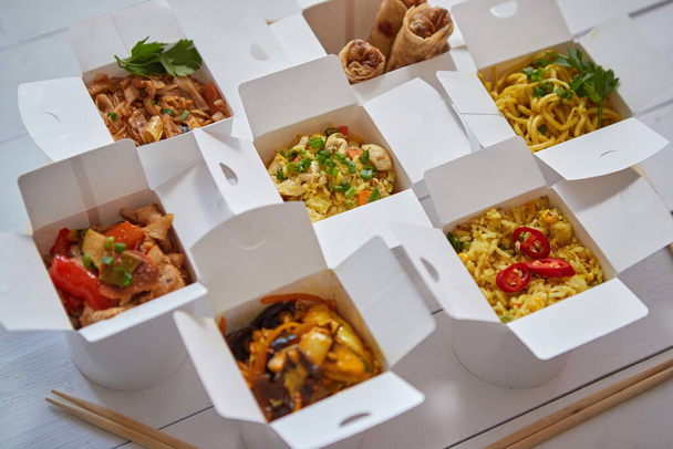 Asiático para llevar o entrega concepto de comida. Cajas de papel colocadas sobre mesa de madera blanca - Foto, Imagen