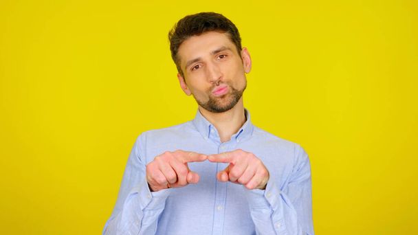 Schöner bärtiger Mann zeigt sexuelle Gesten auf gelbem Hintergrund mit Kopierraum - Foto, Bild