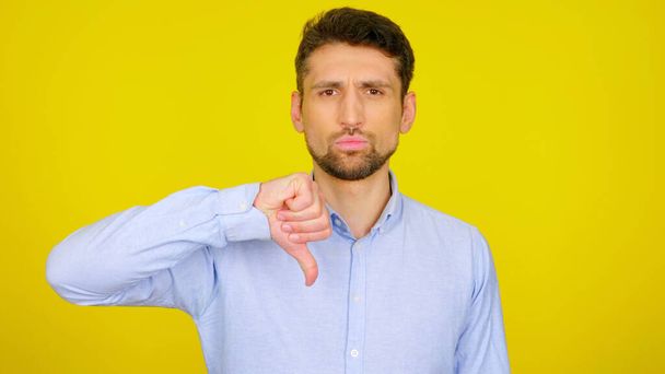 Homem sério mostra antipatia em um fundo amarelo com copyspace
 - Foto, Imagem